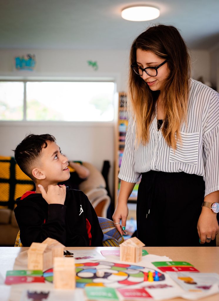 A woman explains to a young boy how to play Taurite.