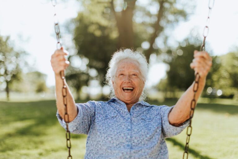 Happy older woman on a swing.